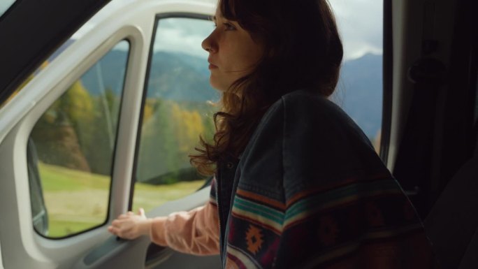 一名女子坐在副驾驶座位上，看着秋天白云石的美景