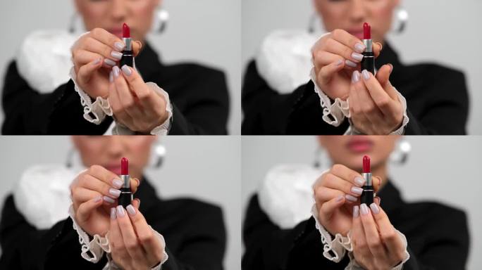 口红是女性的配饰和化妆品。一个浓妆的黑发女人手里拿着口红。产品促销、美容和配件的广告。