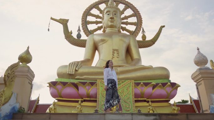 快乐的女人在苏梅岛的大佛寺里探索