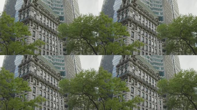 在绿树和商业摩天大楼附近的历史装饰艺术建筑。纽约曼哈顿白天的城市建筑。房子的低角度镜头