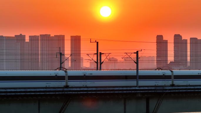 黄昏夕阳下的高铁经过城市大桥