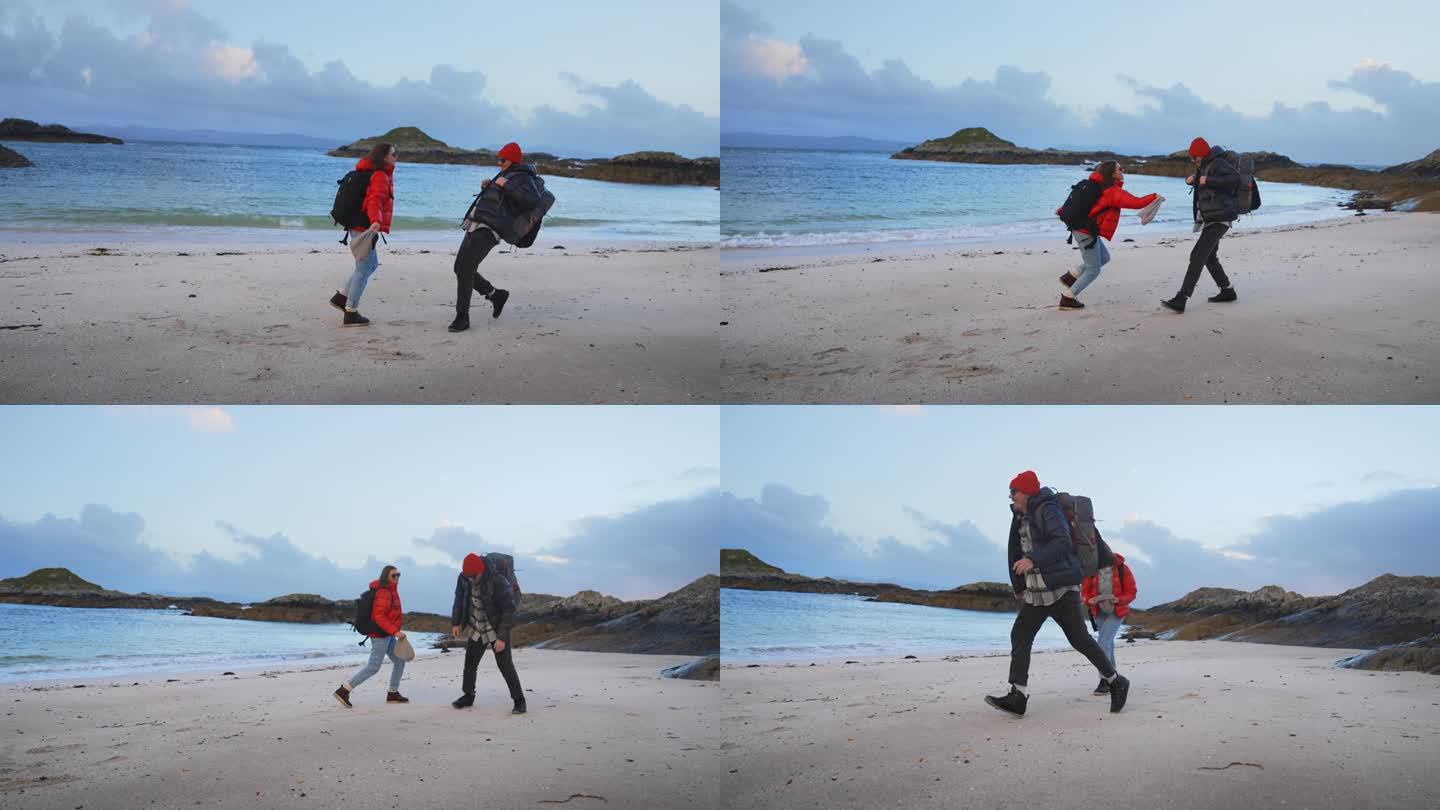 浪漫的情侣穿着保暖的衣服在荒野中散步或徒步旅行。一起在沙滩上玩耍