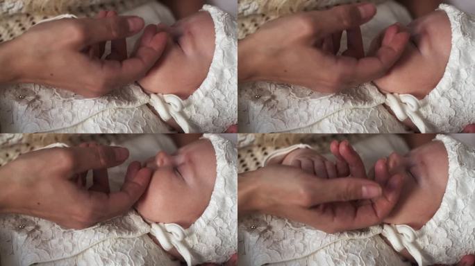 母亲的手掌轻抚着熟睡婴儿的脸颊。
