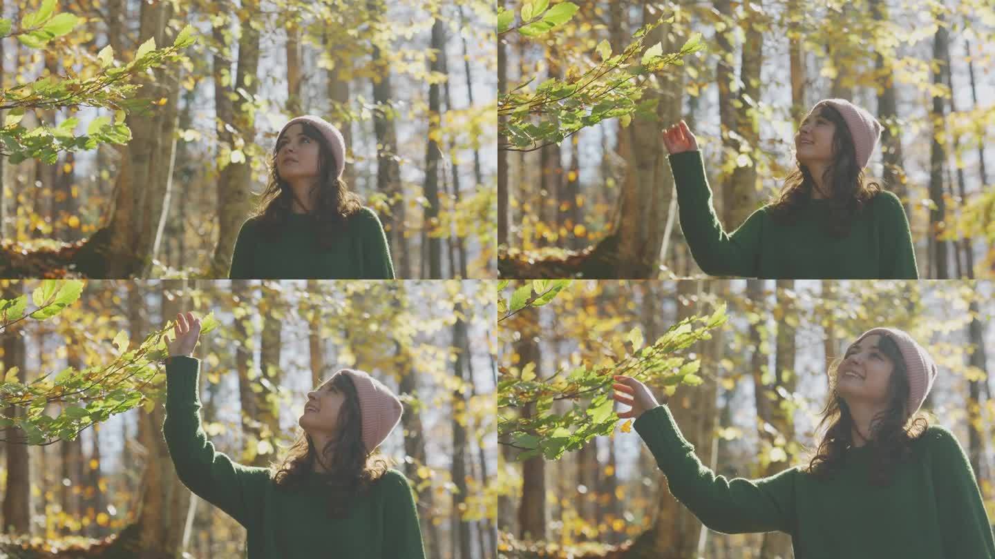 秋天，穿绿毛衣的女人走在森林里
