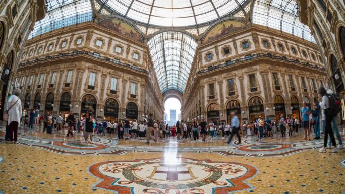 意大利米兰大教堂广场的维托里奥·伊曼纽尔二世画廊，拥挤的游客步行和购物时尚品牌产品的时间流逝