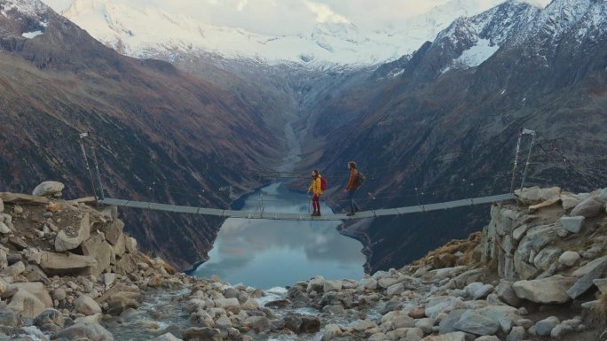 女人和男人在桥上，背景是奥地利阿尔卑斯山的湖