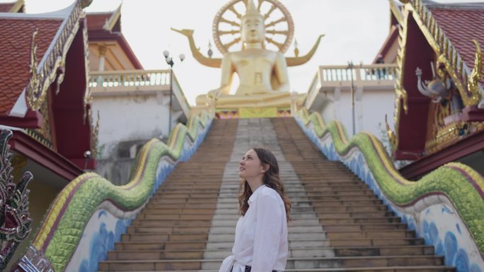 快乐的女人在苏梅岛的大佛寺里探索