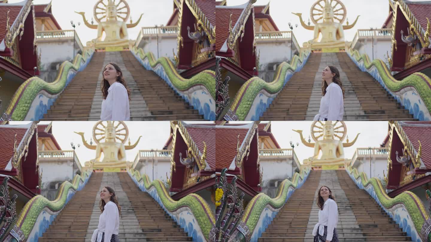 快乐的女人在苏梅岛的大佛寺里探索