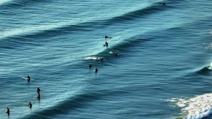 早晨，冲浪者在蓝海冲浪
