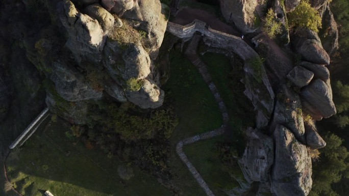 在保加利亚西北部维丁省，一架空中无人机从底部向上移动，显示了Belogradchik岩石堡垒的坚固城