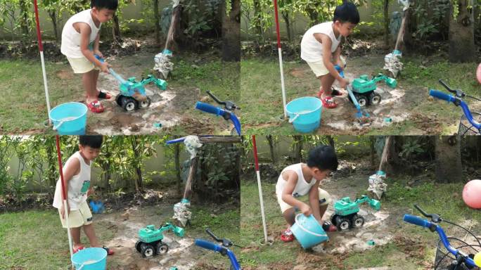 一个男孩在一堆沙子上玩玩具拖拉机。