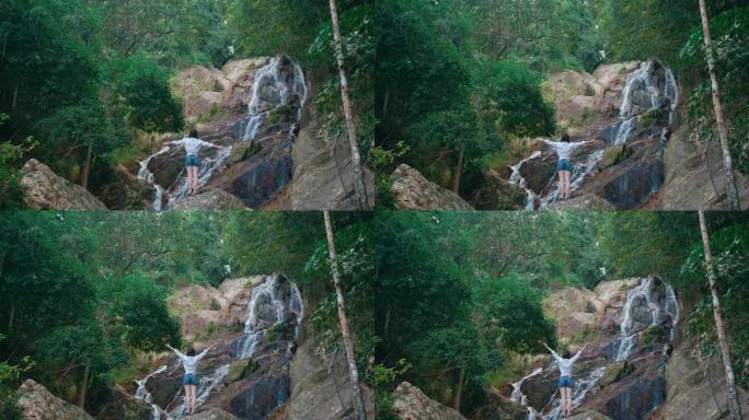 热带岛屿瀑布旁的女人