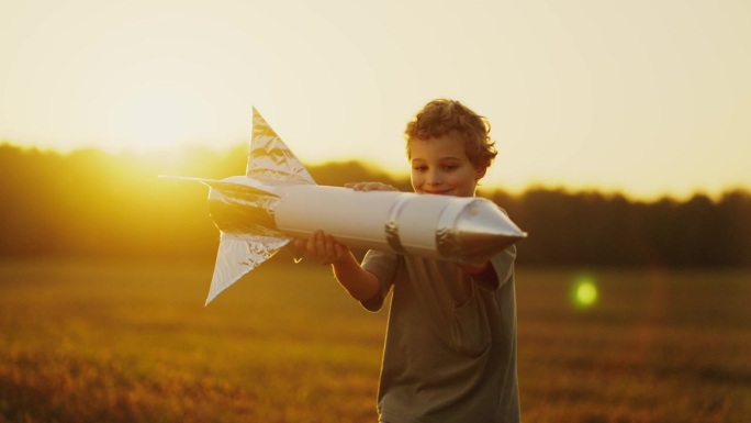 梦想太空和旅行到另一个星球，小男孩玩玩具火箭的肖像
