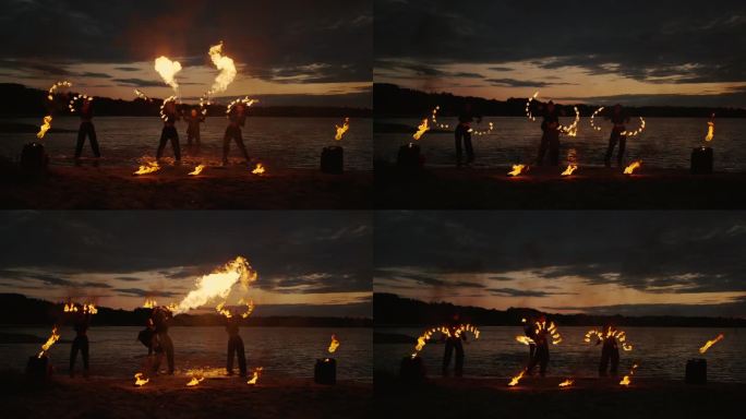 一群手持火把的特技演员在夜晚的海滩上表演火焰表演，令人惊叹的慢动作
