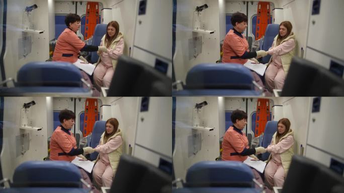 一名救护车护理人员握着一名怀孕女孩的手，测量她的脉搏。