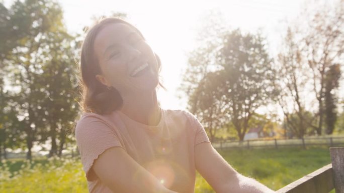 夏日漫步在乡间，倚在篱笆上笑着的女子画像