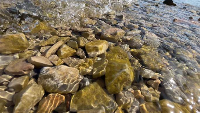 湖水浪花打在石头上波光粼粼