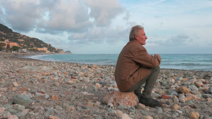 成熟的男人在空旷的海滩上放松