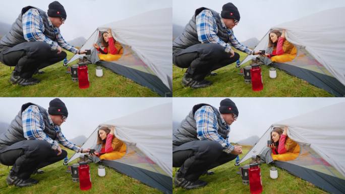 一对浪漫的夫妇穿着暖和的衣服在寒冷的天气里露营。喝热茶