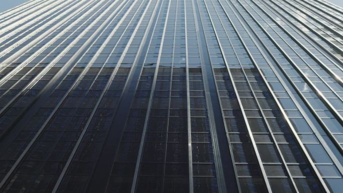 纽约玻璃现代摩天大楼反光表面的低角度抽象镜头。受欢迎的美国旅游和商务目的地。银行、商业和企业概念