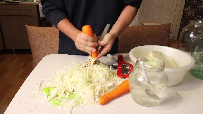 一个男人在家煮酸菜。磨胡萝卜。总体规划