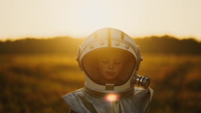 可爱的小男孩穿着太空服，戴着头盔在火星表面行走，梦想着太空
