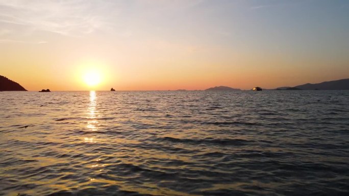 在日落背景下低水位飞越海洋，泰国沙卡通里比岛