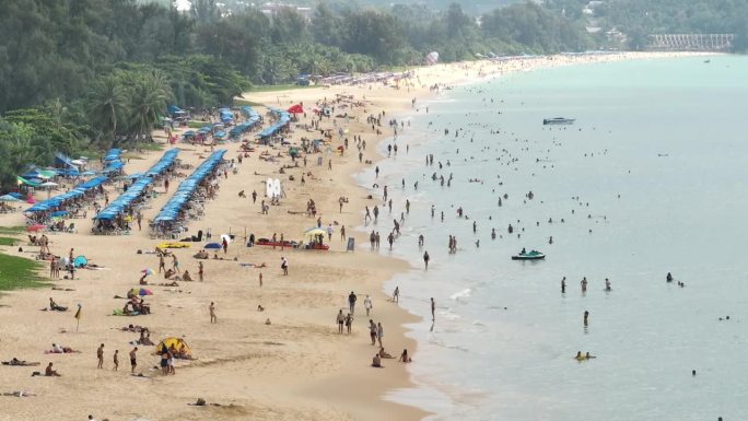 阳光明媚的一天飞越普吉岛著名的游客拥挤的海滩航拍全景4k泰国