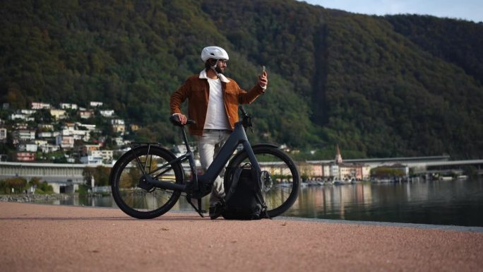 城市骑行，电动自行车通勤者捕捉到湖边的景色