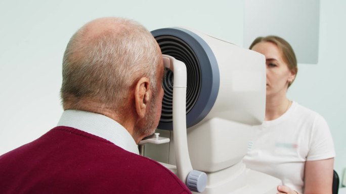 眼科医生在眼科办公室用现代技术检查一位老年病人的眼睛。现代医学的理念，治疗白内障和良好的视力。