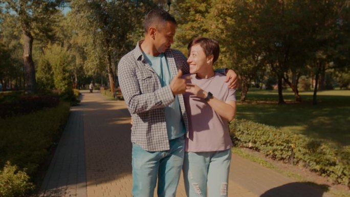 幸福迷人的听障夫妇在夏日公园散步和亲密