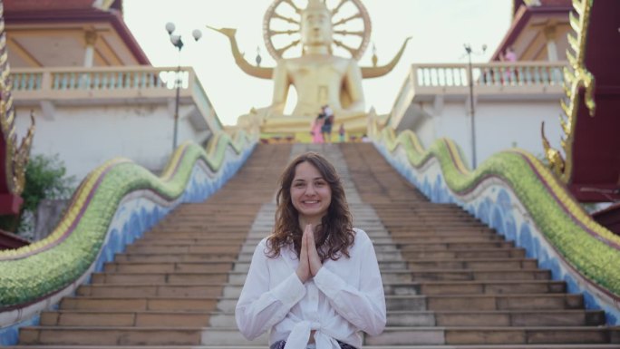 在苏梅岛大佛寺附近，一名妇女举手致意