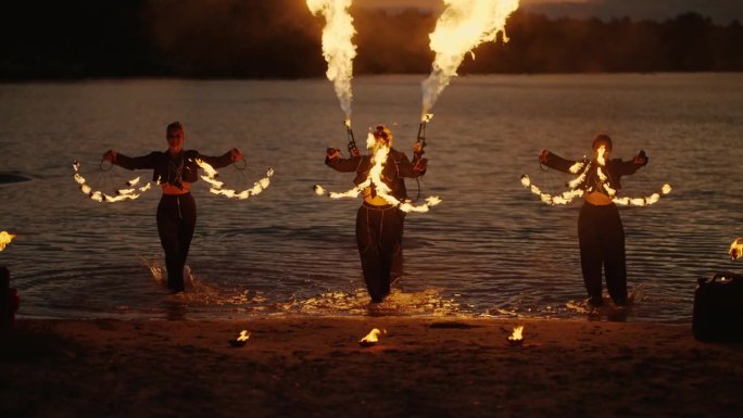 沙滩上的火焰表演，一群手持火把的女艺人表演魔术