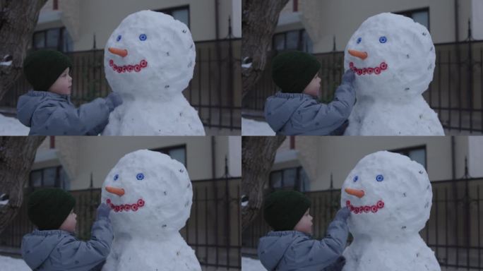 小孩小孩男小孩从雪里堆雪人冬天的一天游戏孩子们在户外