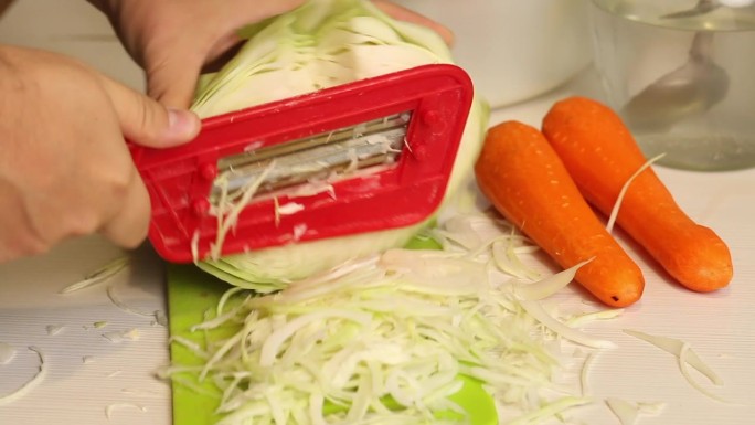 一个男人在家煮酸菜。手工切碎卷心菜。一步步收获酸菜的过程。特写镜头。