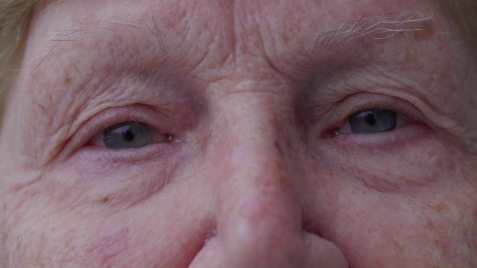 老妇人微距特写盯着镜头，满脸皱纹的老人