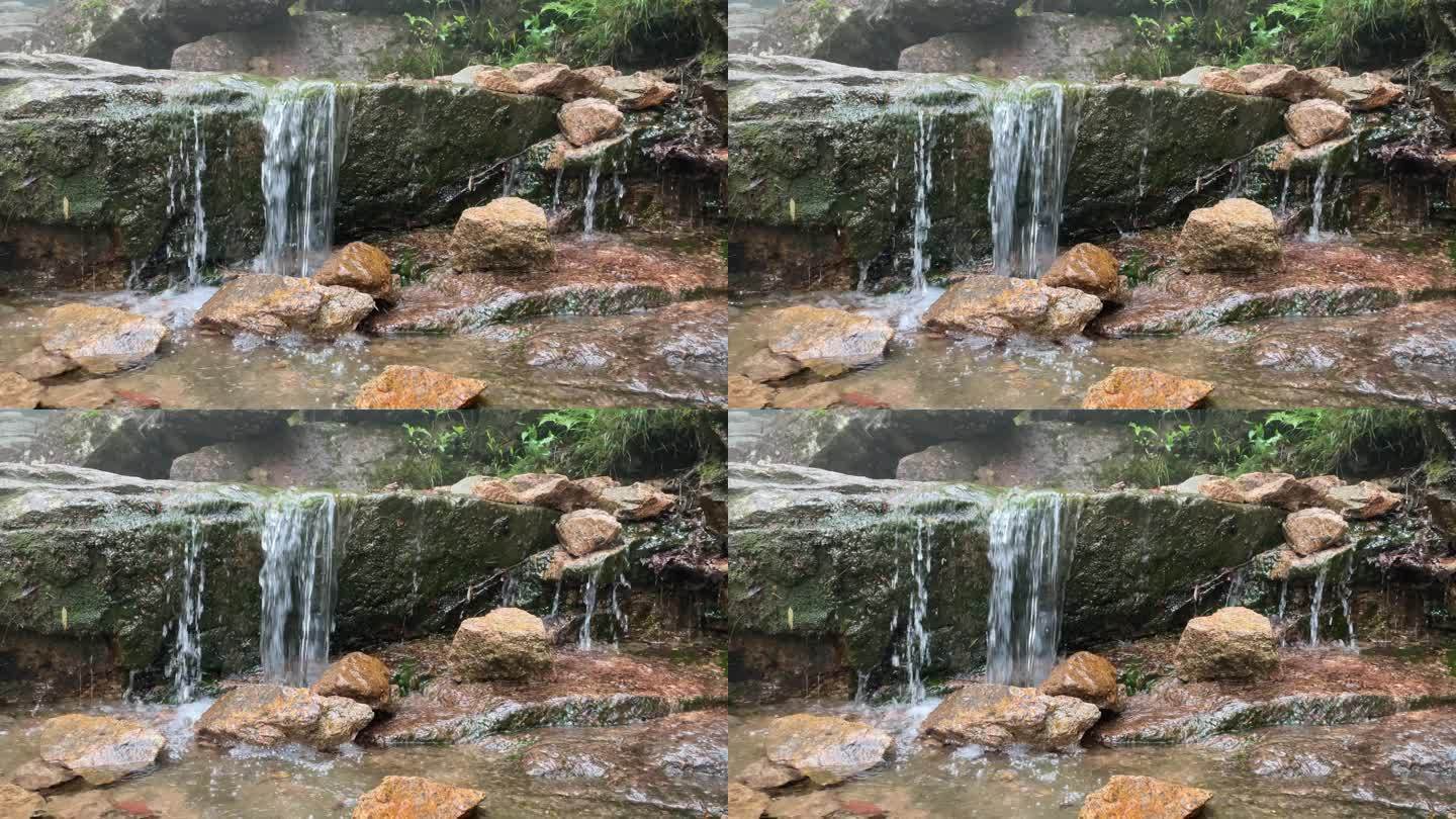 小瀑布水冲刷石头潺潺流水