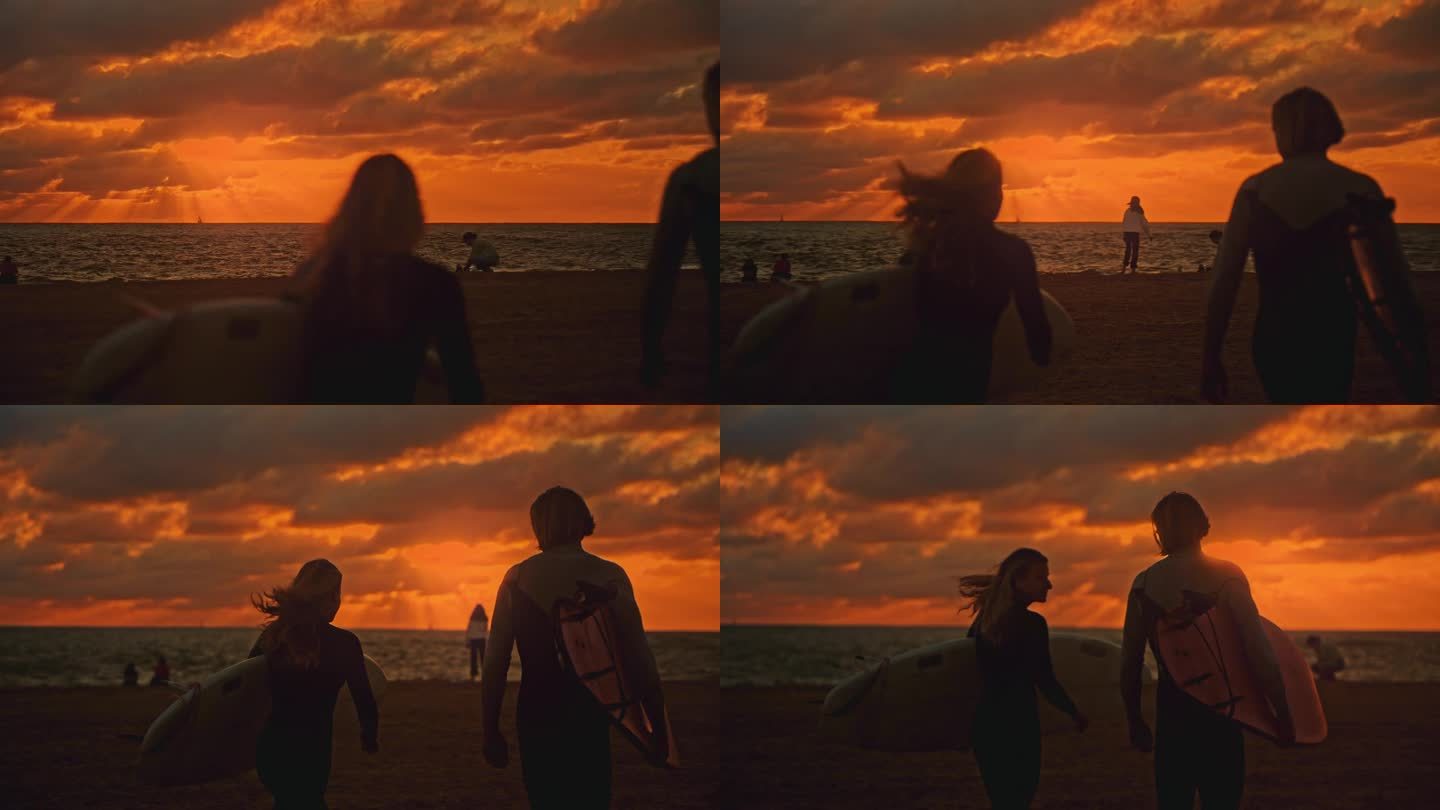 日落时分，一对冲浪夫妇在海边扛着冲浪板