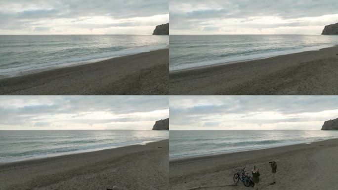 在空旷的海滩上，一对骑着自行车的成熟夫妇的鸟瞰图