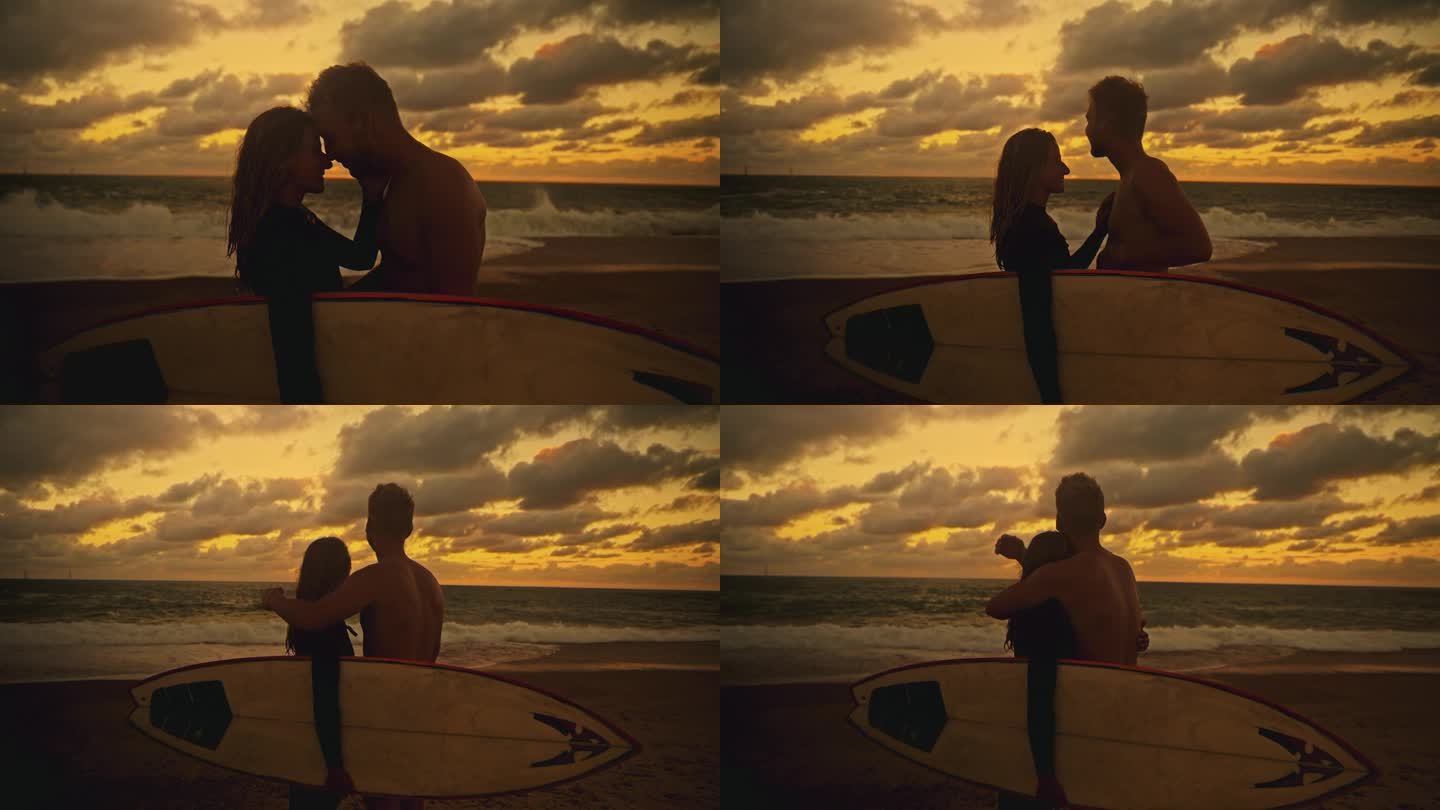 深情的冲浪夫妇拥抱，看着日落的海洋
