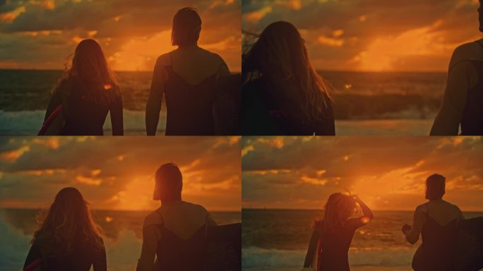 冲浪夫妇带着冲浪板在日落的天空下观看海洋冲浪