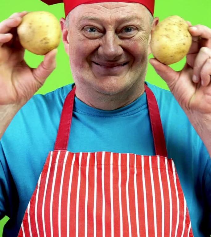 快乐微笑的高级厨师用手捂着眼睛，手里拿着两个土豆。