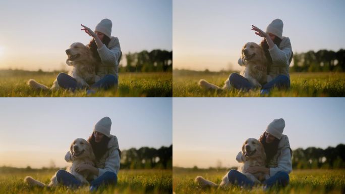 一个女人在草地上和一只金毛猎犬玩耍。抚摸和拥抱腿上的狗