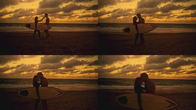 深情冲浪者夫妇拥抱在宁静的海滩在日落