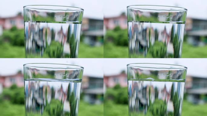 水滴在装满清水的玻璃杯中形成气泡。