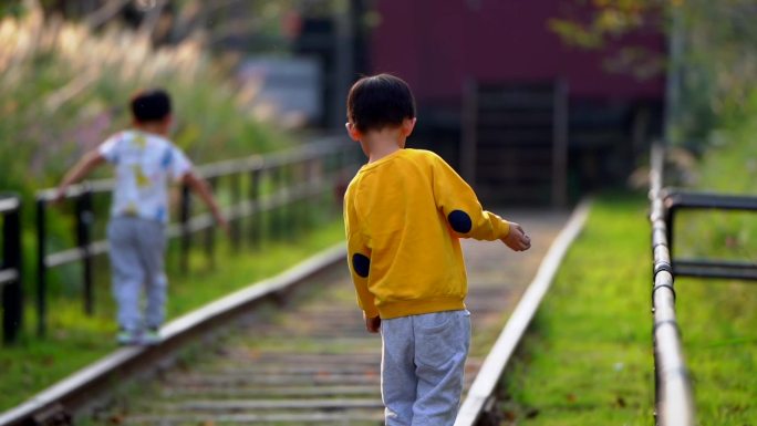 亲子儿童小孩在火车轨道上平衡行走生活美好