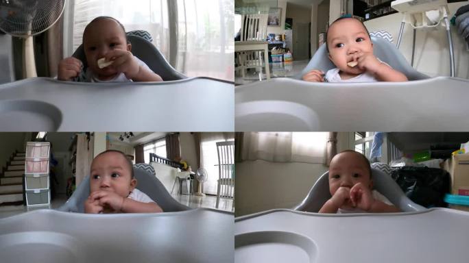宝宝在家里的餐椅上吃零食的特写