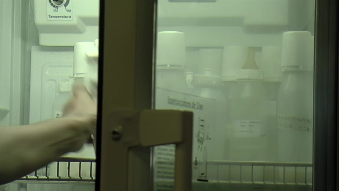 新生儿护士在医院新生儿重症监护室从冰箱里拿奶瓶。特写镜头。