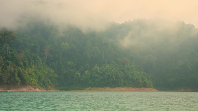 云天清晨，绿树成荫的高原湖岸景色优美，雾气缭绕，是泰国偏远地区自然保护旅游和休闲之旅的美丽景点