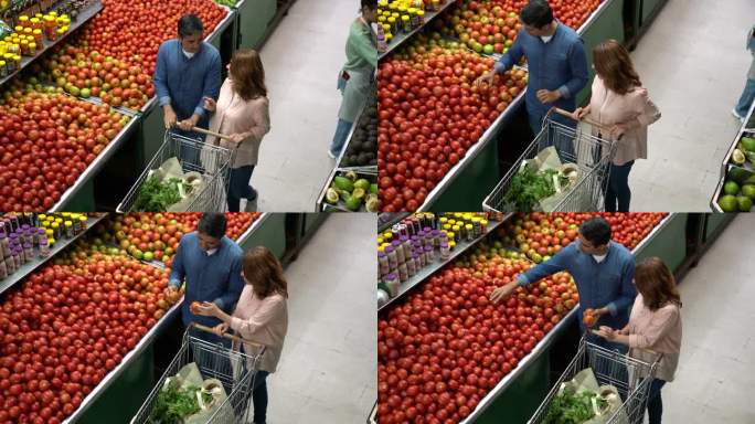 一对拉丁美洲夫妇在市场上一起推着购物车购买新鲜农产品，一边聊天一边添加产品